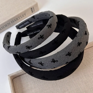 Set of minimalist velvet-textured bow headbands in grey and black with handmade labels