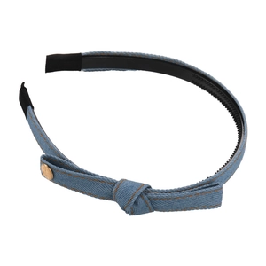 Light blue denim bow headband with orange stitching and golden metal buckle on white background