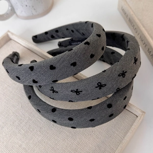 Detailed view of thick wide-brim headbands with heart, bow, and polka dot patterns