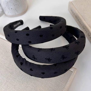 Detail view of black sponge headbands set featuring polka dots and heart patterns