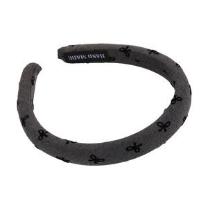 Elegant grey flocked headband with black bow patterns and a handmade label
