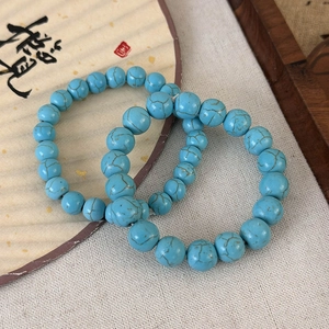 Vue détaillée de deux bracelets en perles turquoise avec texture naturelle sur lin pur