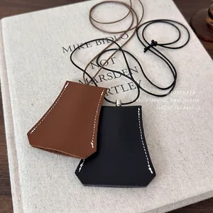 Minimalist leather clochette key case necklaces in brown and black with contrast stitching