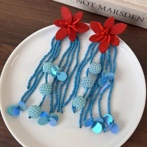 Exaggerated long fringe earrings with red floral tops and blue beaded tassel design