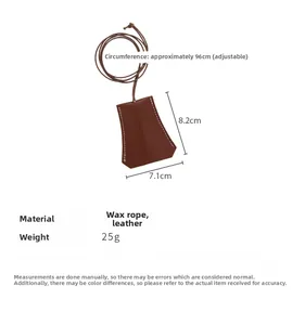 Detailed view of brown leather key pouch with white stitching and adjustable wax rope