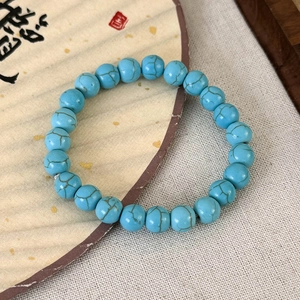 Détail macro du bracelet en perles de turquoise avec veines minérales et cordon élastique