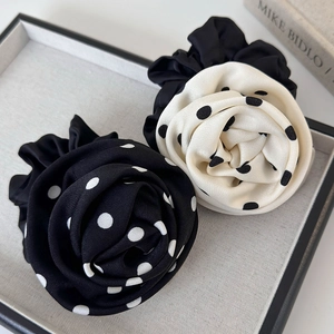 Gros plan d'élastiques à cheveux rose élégants avec motifs à pois noirs et blancs