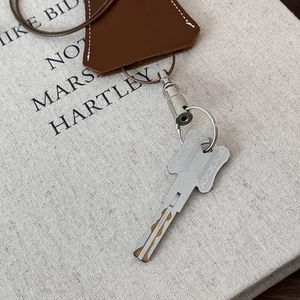 Brown leather key case necklace with fine white stitching and silver metal buckle