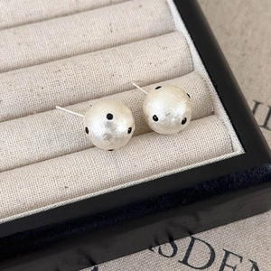 Dettaglio di orecchini a perno con perle a pois in stile francese in scatola regalo