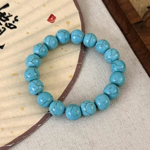 Gros plan de perles de turquoise verte avec veinage naturel sur fond de lin rustique