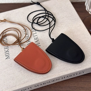 Detail of brown and black leather holder with refined stitching and long strap