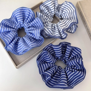 Gros plan détaillé de chouchous en tissu à rayures bleues et blanches dans un lot de 3 pièces