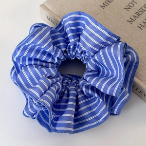 Gros plan sur le chouchou en tissu rayé bleu et blanc avec coutures détaillées