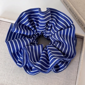 Vue macro d'un chouchou en tissu à rayures bleues et blanches avec texture plissée