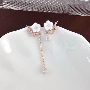 Detail of rose gold plum blossom earrings with zircons and long asymmetrical tassels