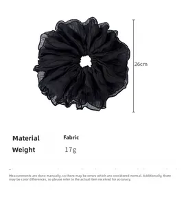 Detail of 26cm oversized black pleated fabric scrunchie with lightweight texture