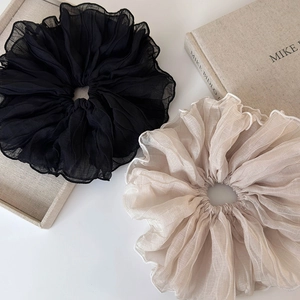 Elegant oversized pleated chiffon scrunchies in black and champagne on white table