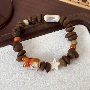 Detailed shot of beaded bracelet featuring coffee beans and a ceramic Shiba Inu charm