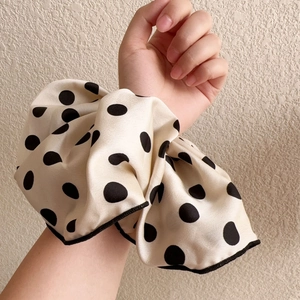 Elegant beige polka dot oversized hair scrunchie with silk texture and black trim edges