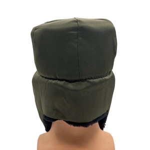 Detail of dark green winter trapper hat with warm black faux fur lining and ear flaps