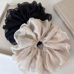 Detail of black and beige oversized organza scrunchies with elegant ruffled edges