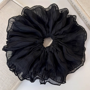 Detailed close-up of large black pleated chiffon scrunchie showing fine fabric texture