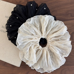 Detail of pleated chiffon scrunchies with faux pearl edges in black and cream beige colors