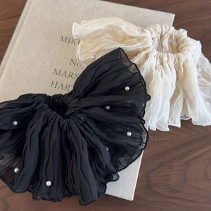 Detailed view of elegant chiffon scrunchies with white faux pearls in black and cream colors