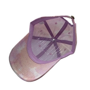 Detailed interior of a tie-dye baseball cap with purple stitching and metal buckle