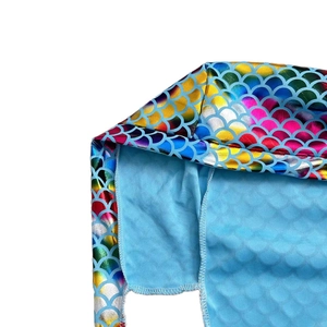 Detail of vibrant mermaid scale sequins and soft blue knit lining on a pirate headscarf