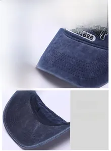 Detail of washed cotton sun visor showing firm curved brim and EST.1928 embroidery