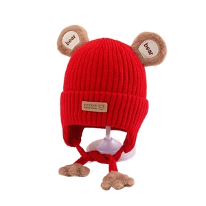 Detail of red knitted winter hat for kids with bear ears and warm fleece lining