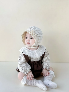 Detailansicht eines Baby-Outfits mit Spitzenkragen-Hemd und Waffelstrick-Latzhose