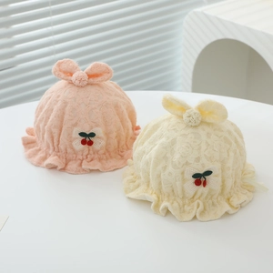 Détail de chapeaux en dentelle pour bébé rose et beige avec broderie cerise et nœuds