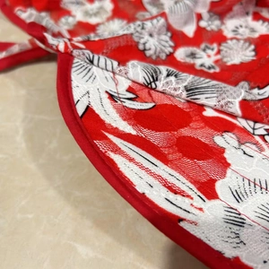 Close-up of red floral lace sun hat detailing with satin trim and intricate white stitching