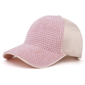 Detailed close-up of a pink baseball cap decorated with dense faux pearls and beads
