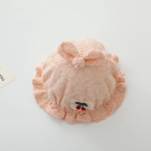 Détail du bonnet princesse en dentelle pour bébé avec gros nœud et cerise brodée