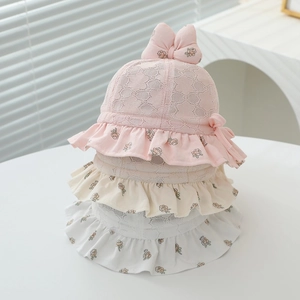 Detail of baby lace fisherman hats in pink, beige, and white with floral brims and ruffles