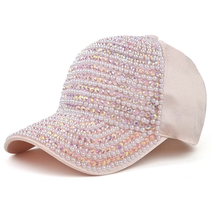 Détail de casquette rose avec perles irisées et ornements en strass brillants