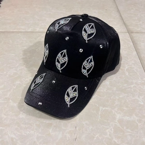 Detailed macro view of black baseball cap featuring sparkling silver rhinestone leaf patterns