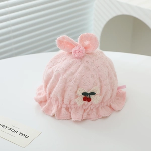 Détail du béret en dentelle rose pour bébé avec oreilles de lapin et nœud cerise