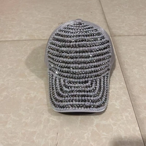 Gros plan détaillé des strass et perles sur la casquette de baseball en satin violet