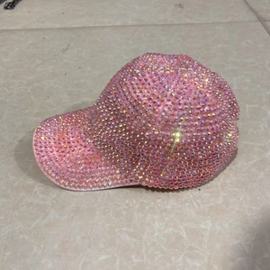 Detail shot of the pink rhinestone baseball cap showing the sparkling crystal embellishments