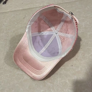 Internal view of pink rhinestone baseball cap showing white support band and metal buckle