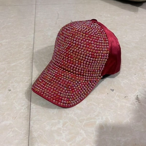 Detailed close-up of vibrant deep red baseball cap with sparkling colorful rhinestones