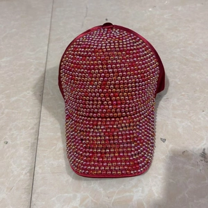 Close-up of red satin baseball cap featuring gradient faux pearl embellishments