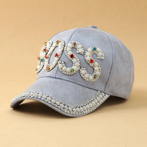 Dettaglio del logo BOSS in strass e perle su un cappello da baseball in camoscio blu