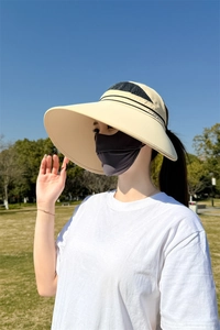 Detail von beigem Sonnenhut mit breiter Krempe und dunkelgrauer Gesichtsmaske im Set