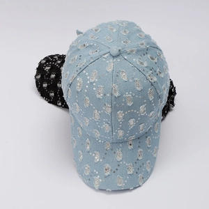 Detail view of denim baseball caps featuring silver sequins and distressed ripped edges