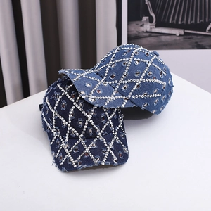 Close-up of rhinestone studded denim baseball caps in dark and light blue with distressed texture